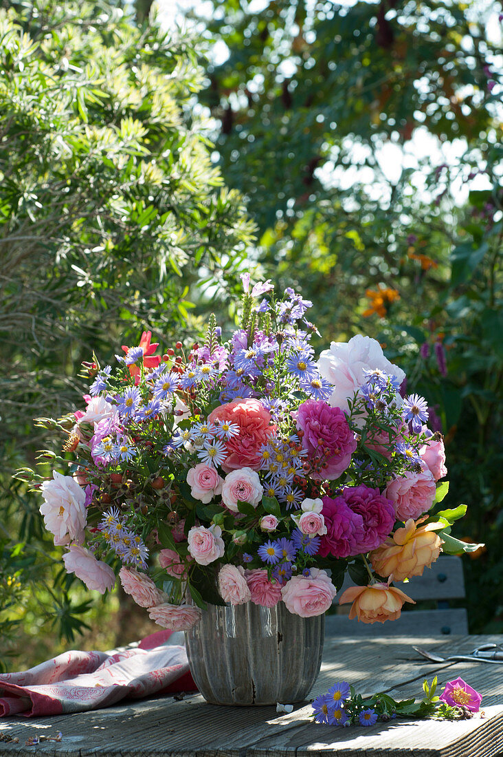 Autumn bouquet with roses, asters and rose hips