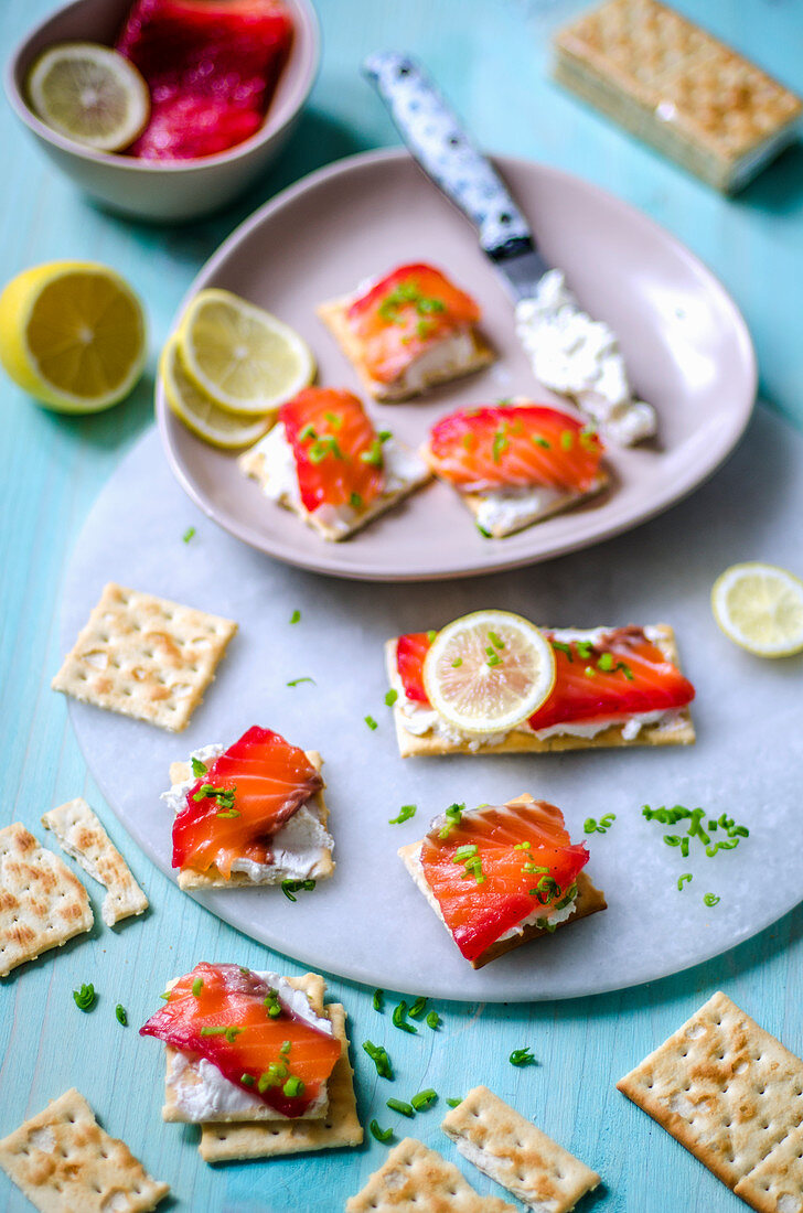Crackers with cream cheese and lightly salted salmon, lemon and green onions