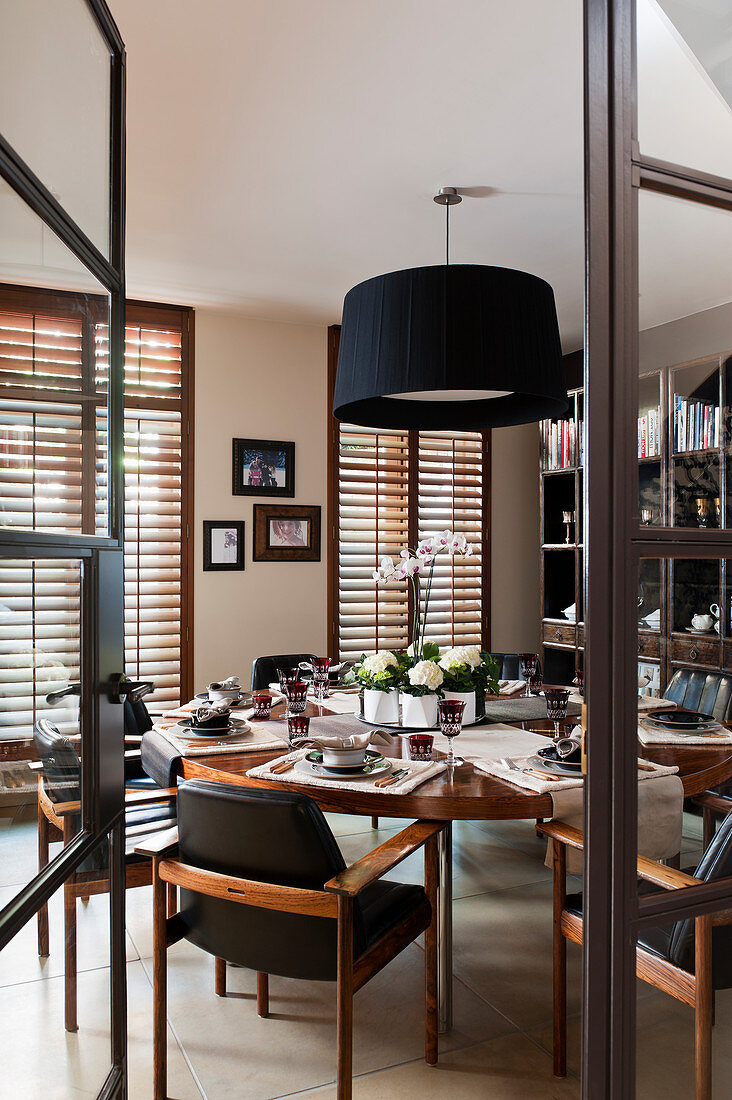 View through open glass door into dining room with round set table