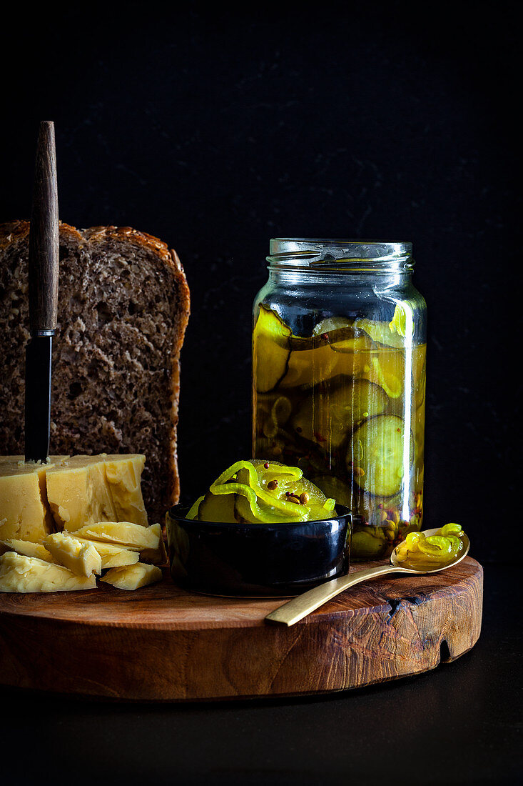 Pickled cucumber slices served with bread and cheese