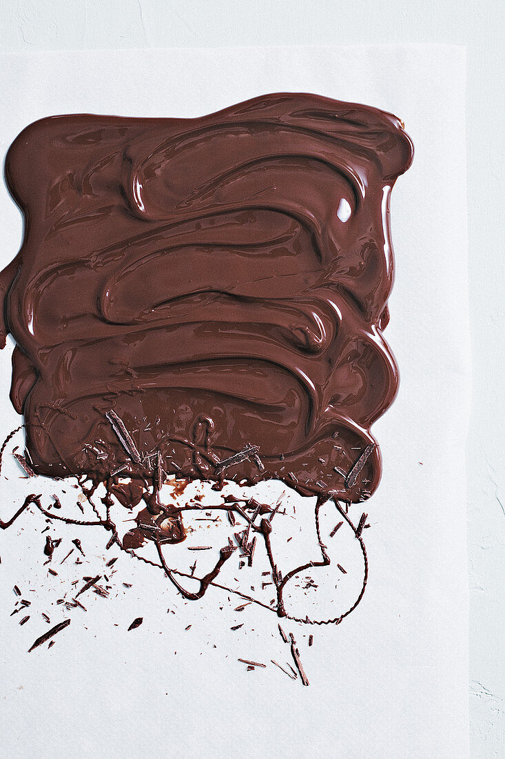 Flüssige Schokolade auf weisser Fläche verstrichen und Kleckse