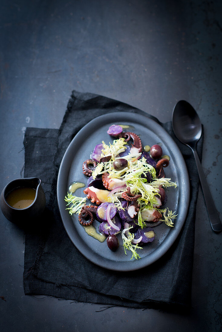 Frisee lettuce and octopus salad with purple potatoes