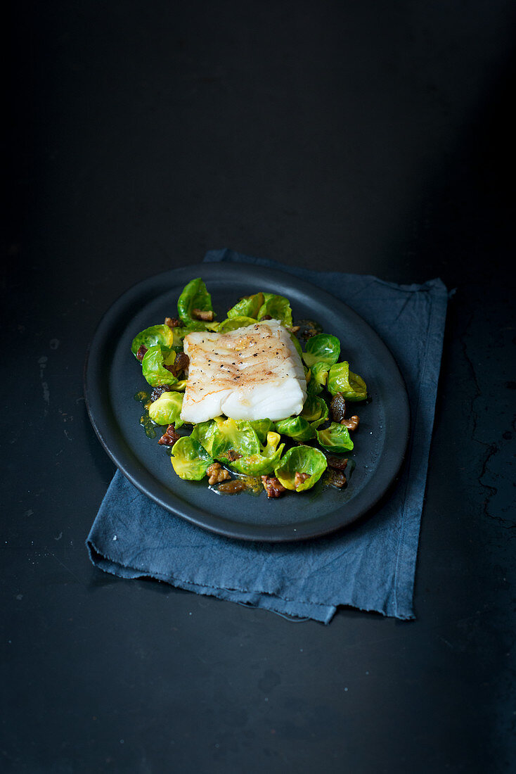 Fried fish fillet on Brussels sprouts with bacon