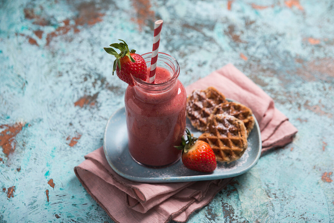 A strawberry smoothie served with biscuit baked in a waffle iron (vegan)