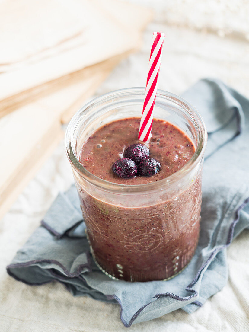 Red brain power smoothie with leafy greens, avocado and frozen blueberries