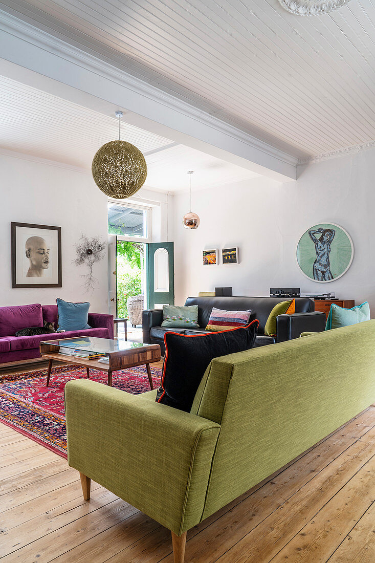 Dark leather, purple velvet and lime-green sofas in living room