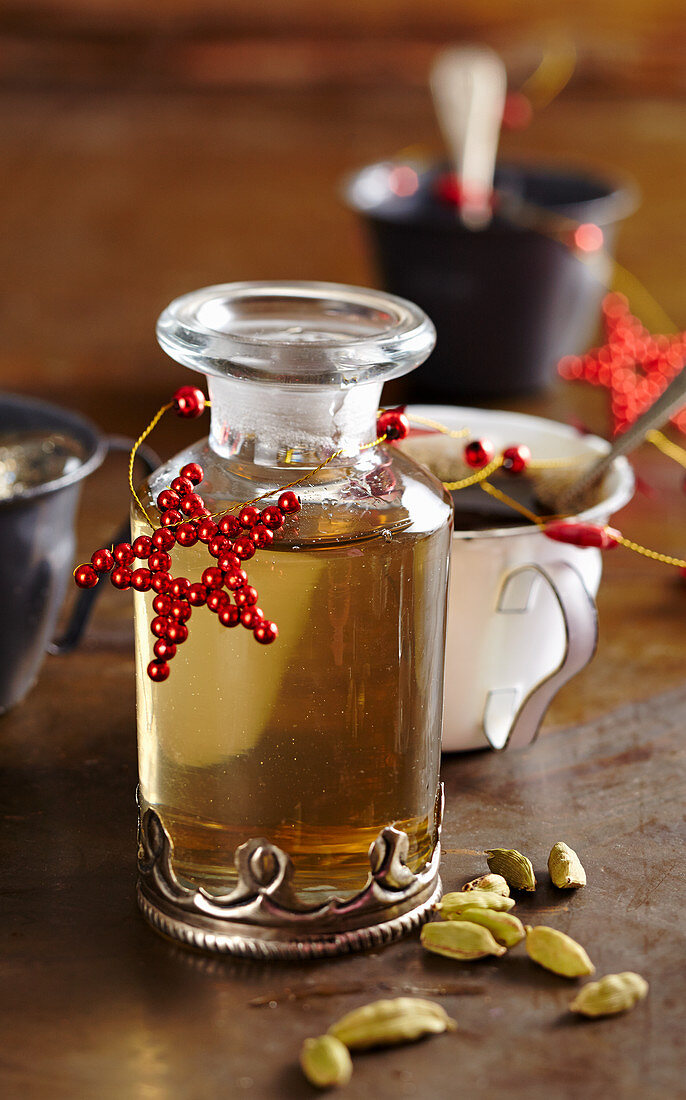 Homemade cardamom syrup in a glass carafe for Christmas