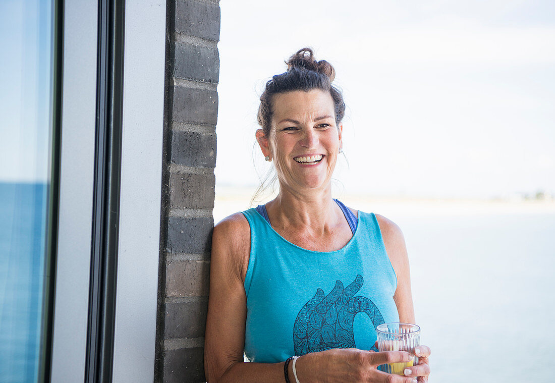 Middle-aged woman in blue top holding drink