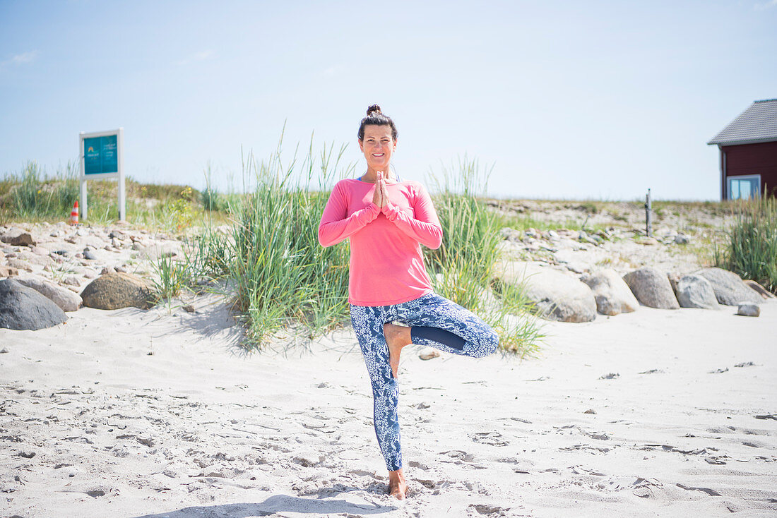 Woman doing yoga on beach