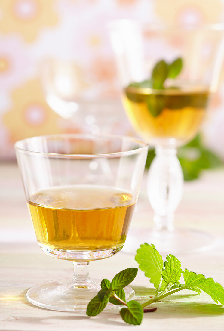Homemade spiced herbed liqueur with peppermint and lemon balm