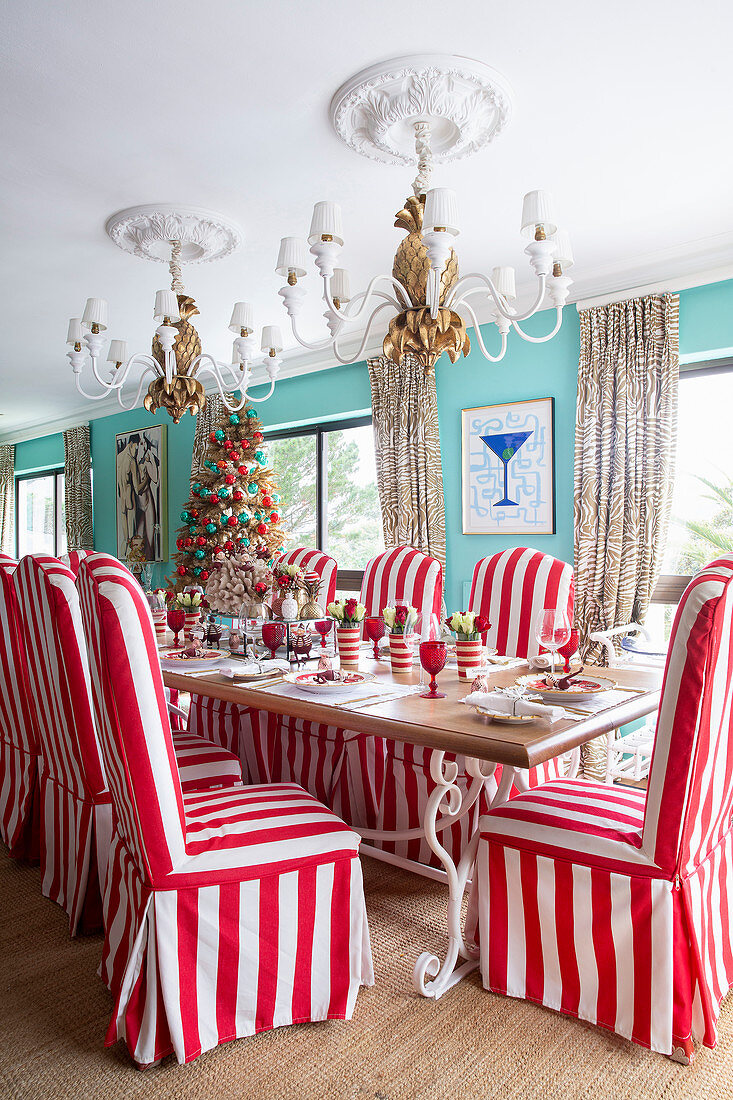 Chairs with red-and-white striped loose covers around festively set table