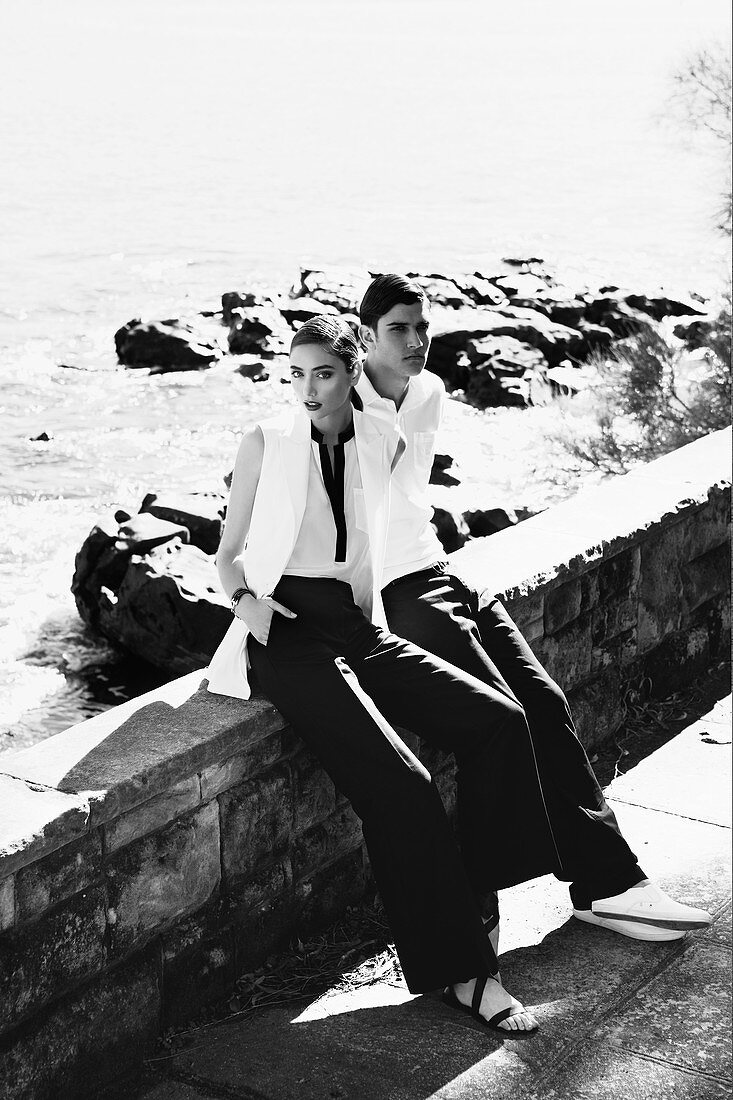 A young couple by the sea wearing black-and-white outfits (black-and-white shot)