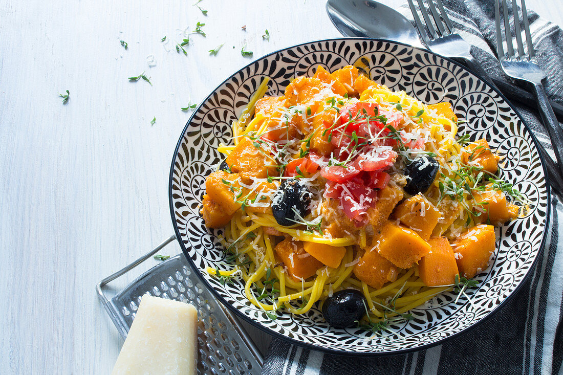 Kürbisspaghetti mit Kürbisragout, Tomaten, Oliven und Parmesan