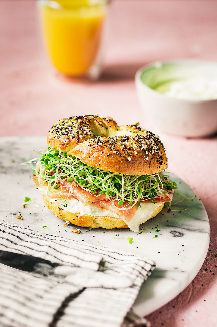Home made bagel with prosiutto and clover sprouts