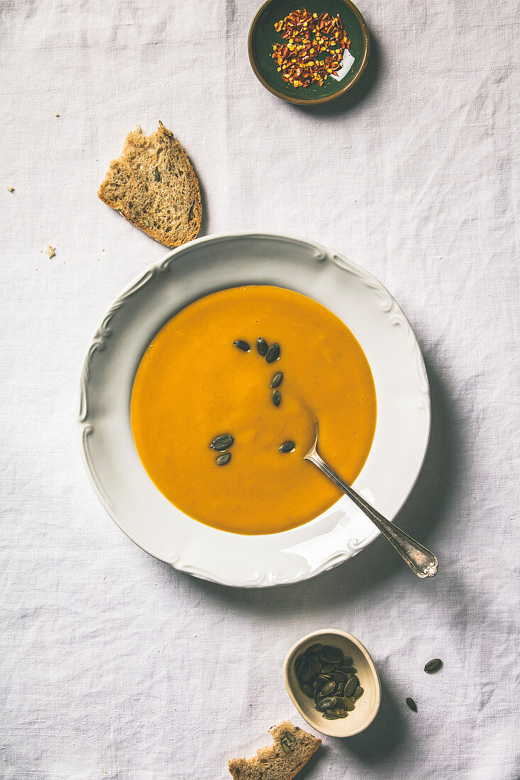 Herbstliche Kürbiscremesuppe mit Kürbiskernen und Brot