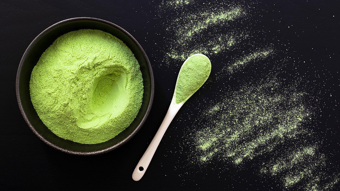 Matcha tea powder in a bowl and on a spoon