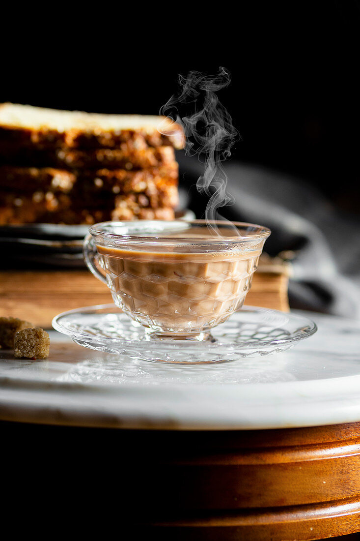 Dampfende Tasse Chai Latte serviert mit Kuchen