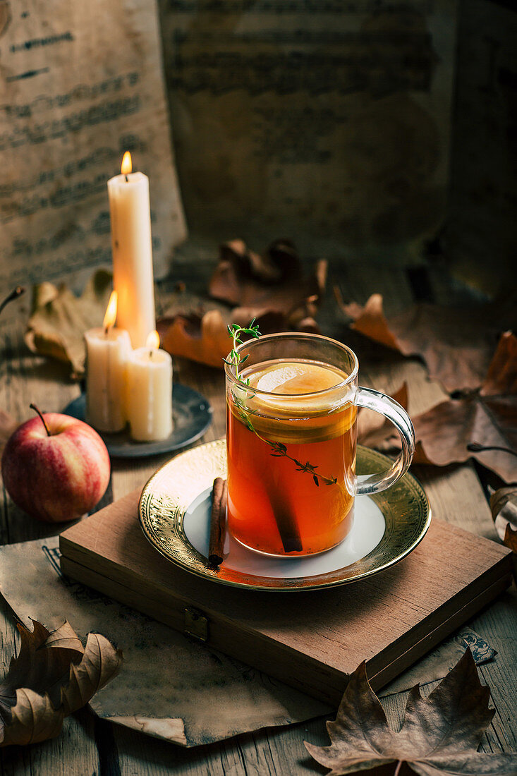 Heisser Tee im Glas mit Zitrone, Apfel, Zimt und Thymian