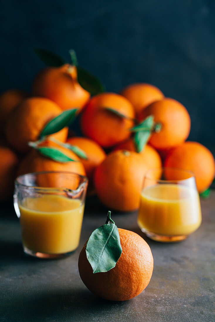 Orangensaft und frische Orangen auf Tisch