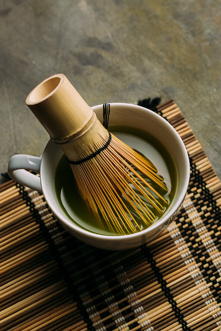 Preparing matcha tea with bamboo whisk