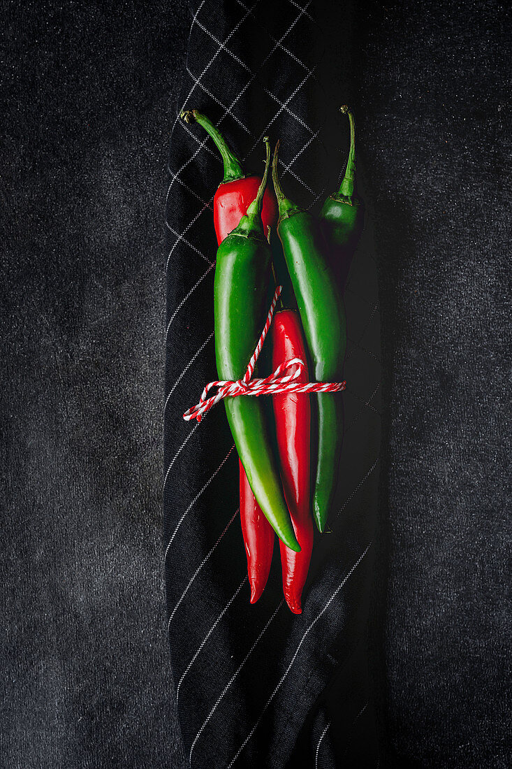 Fresh red and spicy chilli peppers on dark background