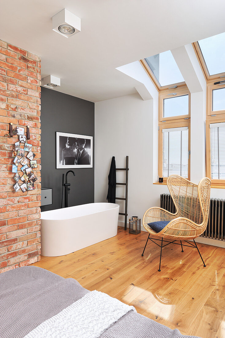 Bathtub in open-plan, loft-style interior with exposed brickwork