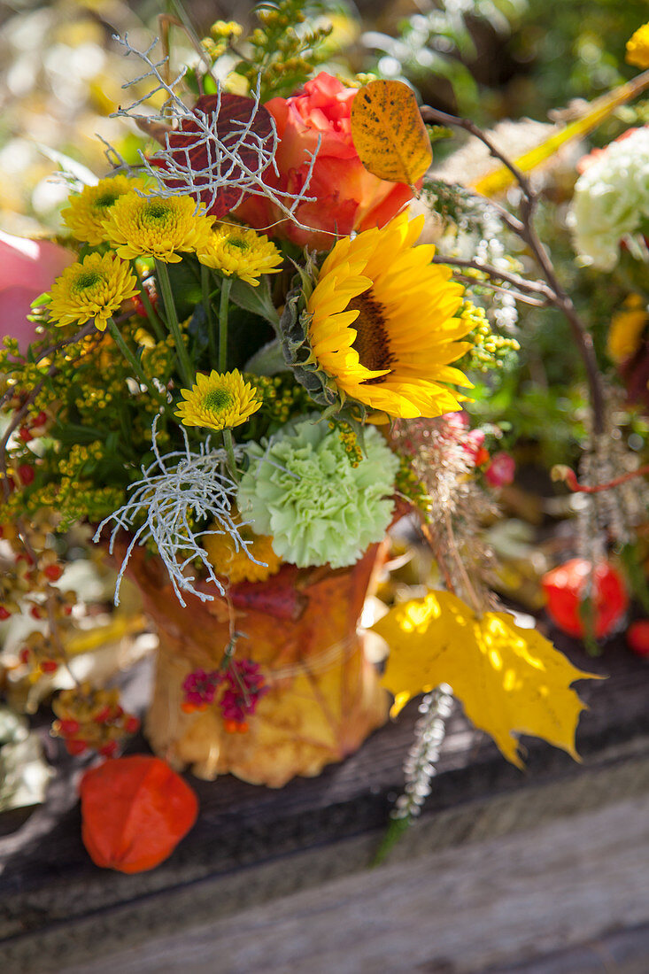 Gesteck mit Sonnenblume, Rose und Chrysanthemen