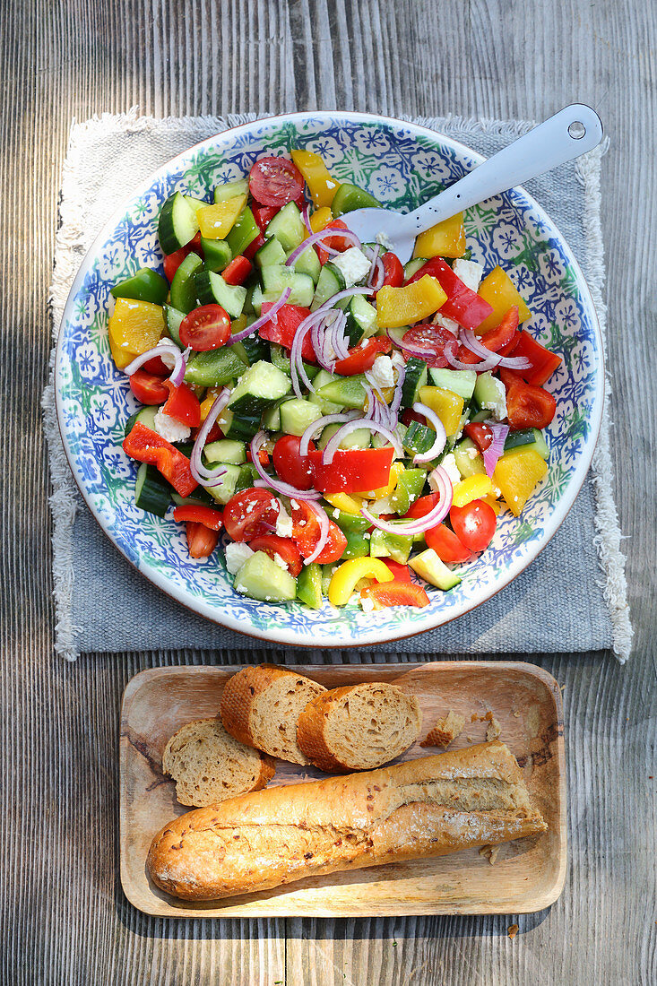 Country salad with cucumbers, tomatoes, peppers and onions