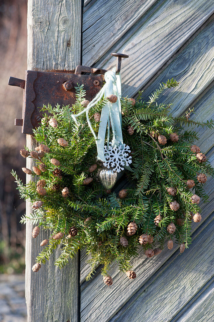 Hemlock door wreath with small pinecones
