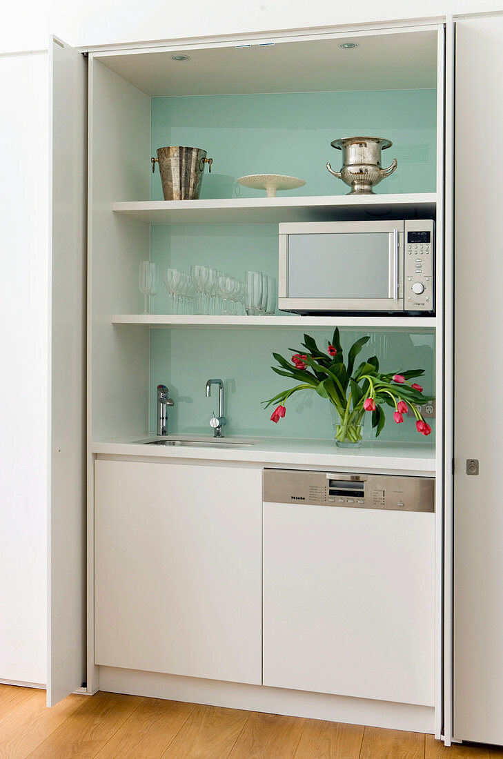 Hidden kitchen behind open doors in the built-in closet