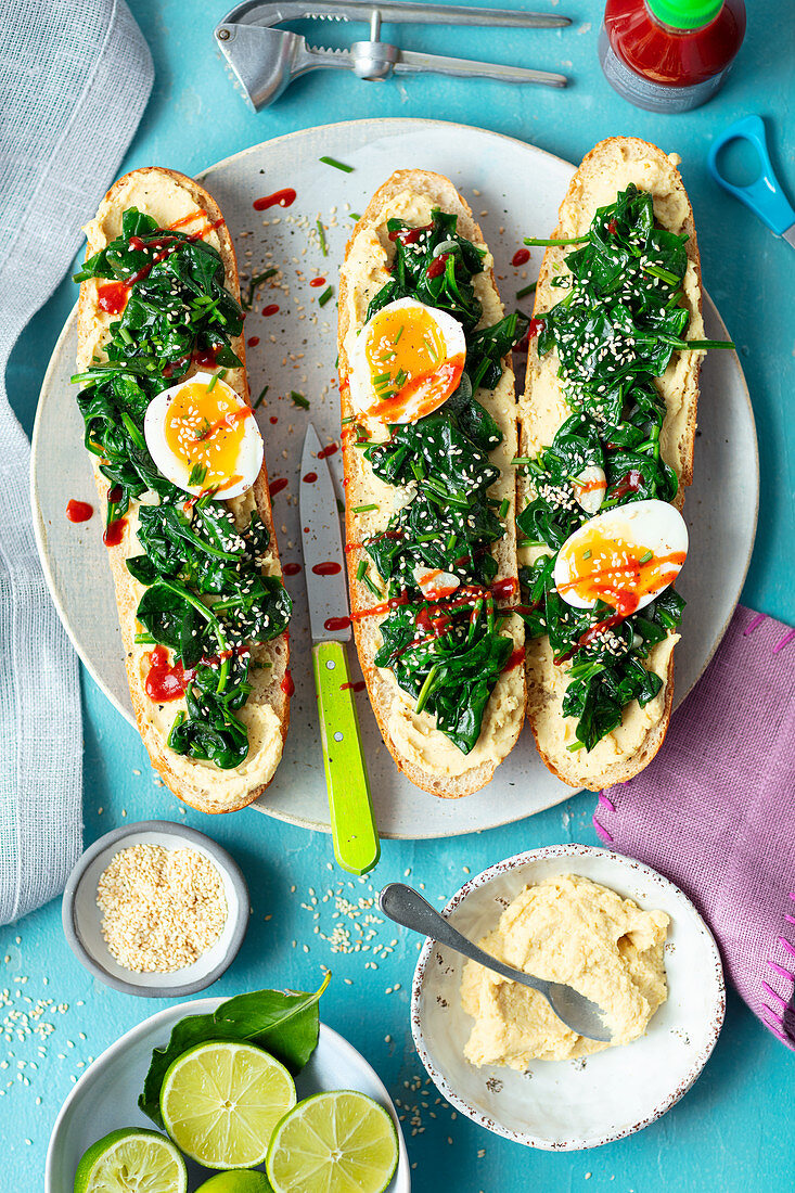 Bread rolls with hummus, spinach and egg