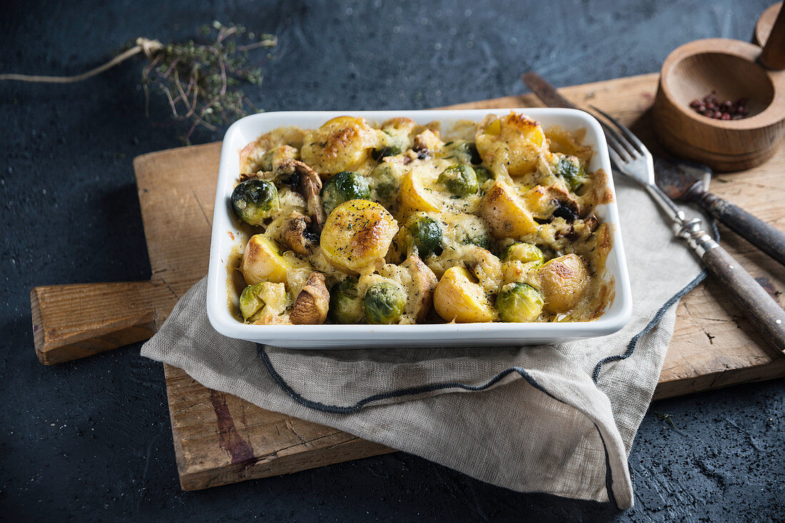 Vegan casserole with potatoes, Brussels sprouts and mushrooms, baked with a cheese substitute