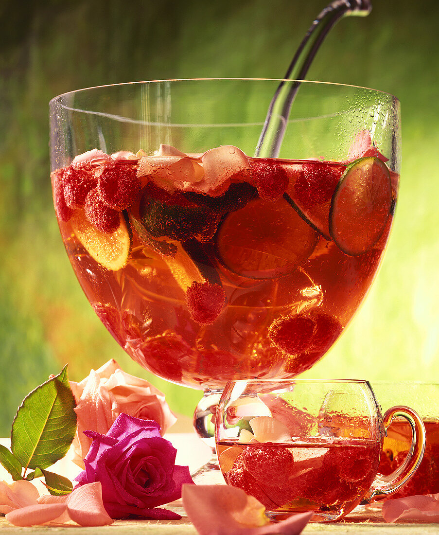 Rose punch with raspberries, limes and rose petals