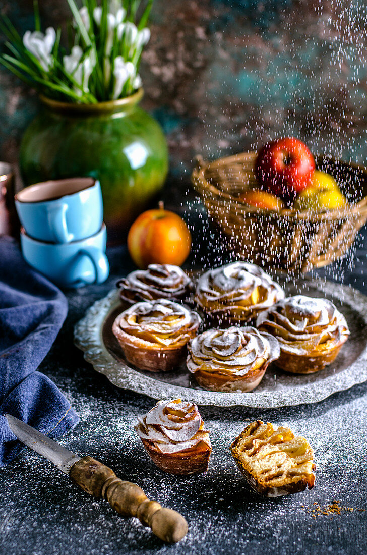 Buns with roses from apples, sprinkled with powdered sugar