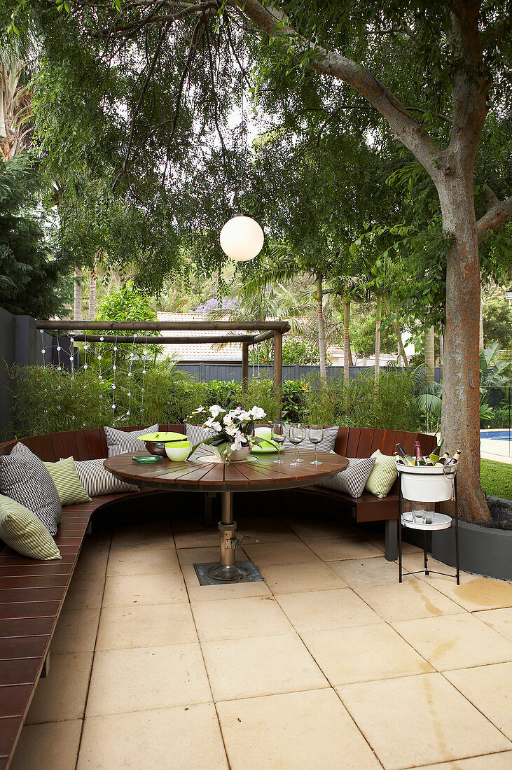 Round bench and table on the terrace under the tree