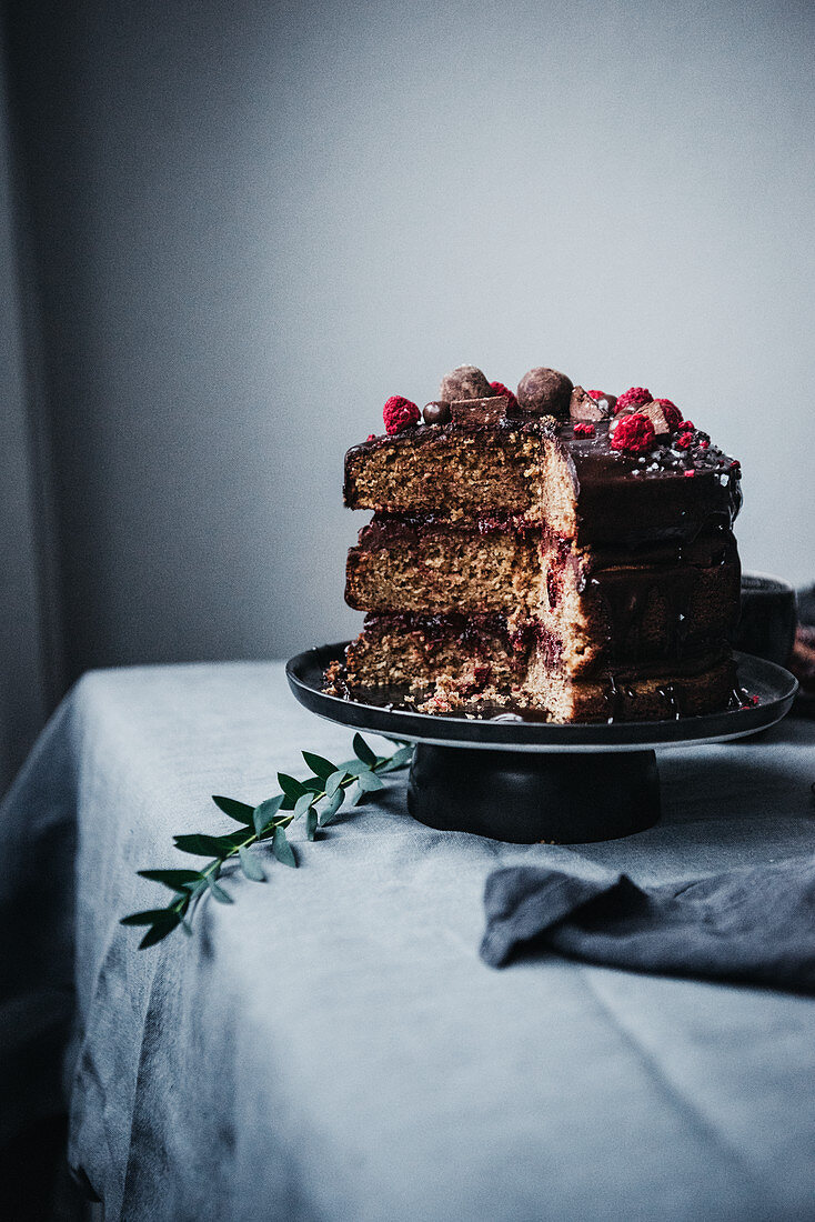 Paleo hazelnut cake with cranberry sauce and a chocolate glaze