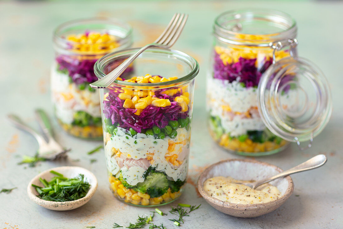 Schichtsalat mit Gemüse, Schinken, Eiern und Mayonnaisesauce im Glas