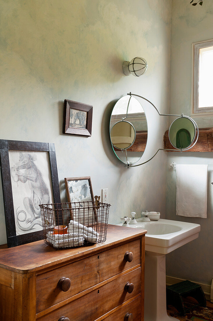 Vintage-style bathroom with painted wall and old wooden chest of drawers