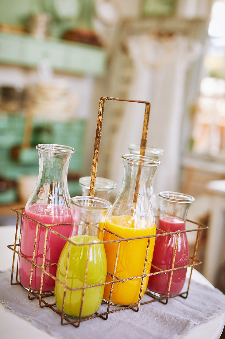 Various smoothies in bottles in an old-fashioned bottle holder