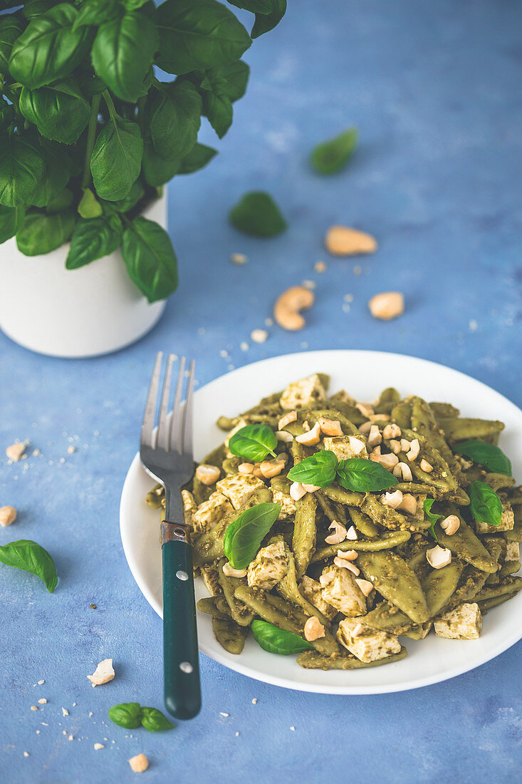 Spinach pasta with pesto, tofu and nuts