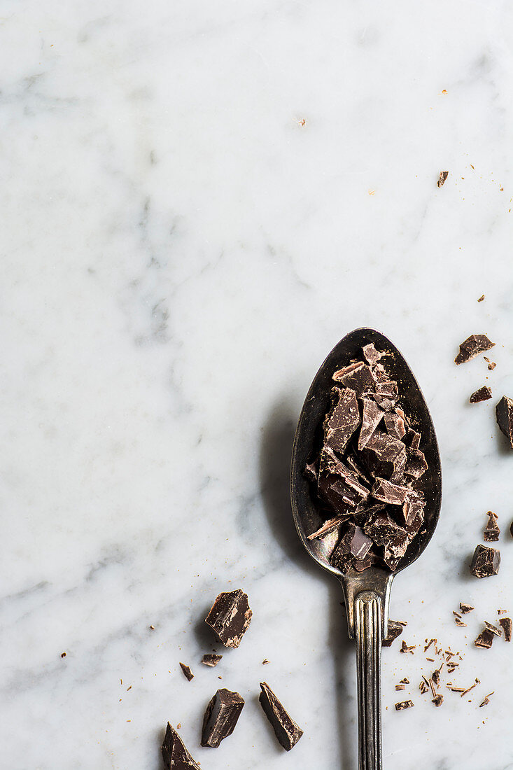Chopped dark chocolate on a spoon