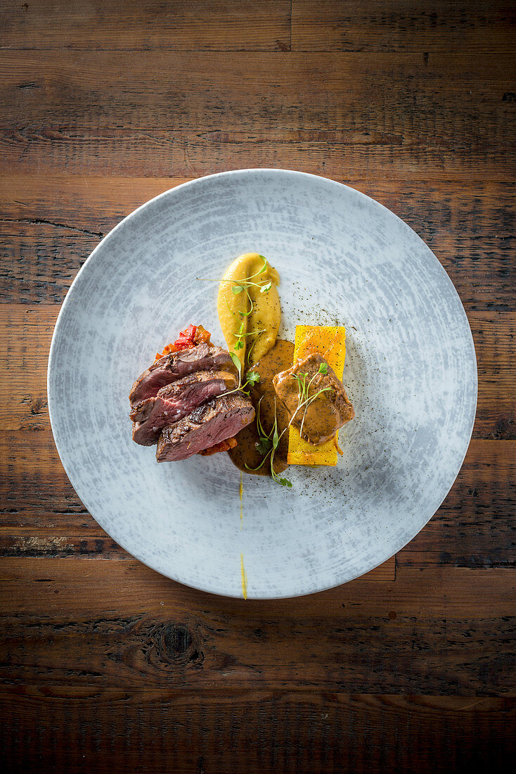 Smoked saddle of lamb with oriental ratatouille curry soubise