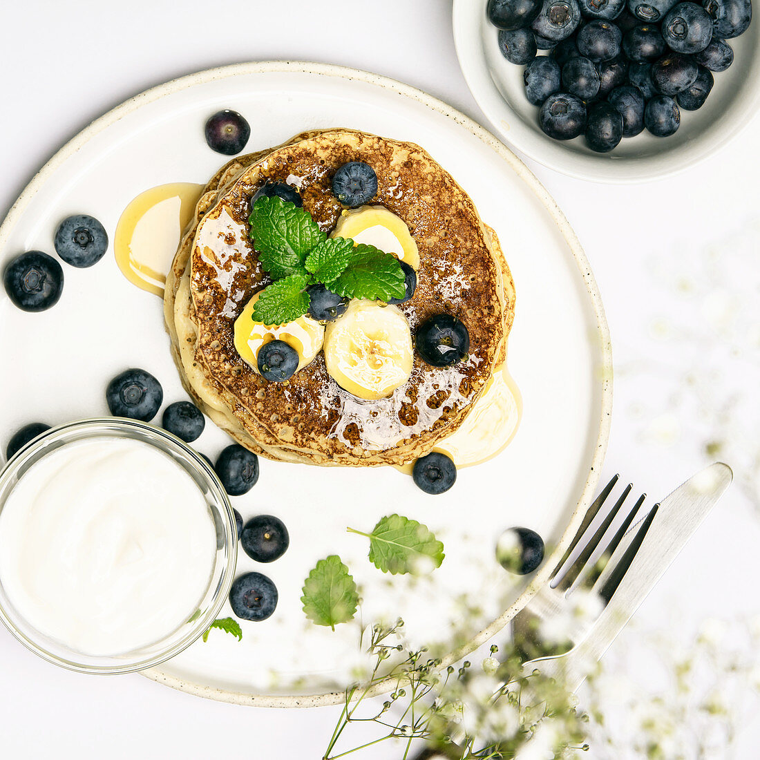 Banana oat pancakes with fruits, berries and maple syrup