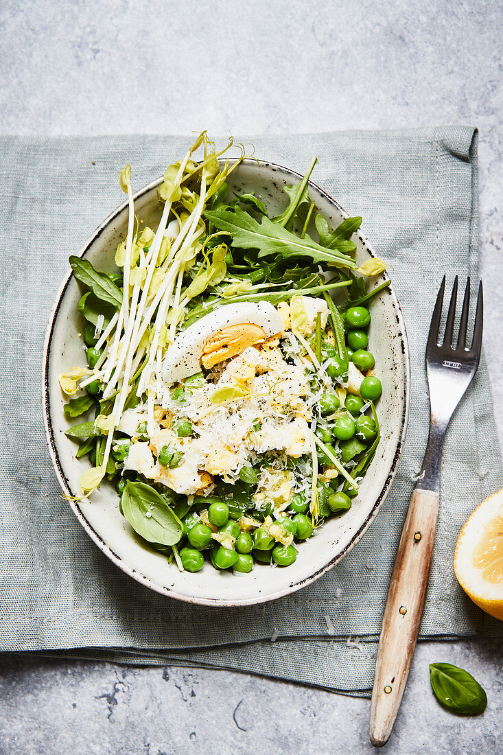 A pea salad with pea shoots and egg