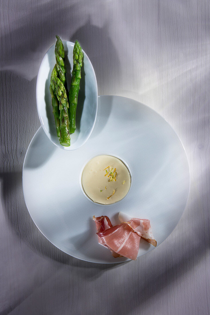 Green asparagus served with ham and sauce Hollandaise