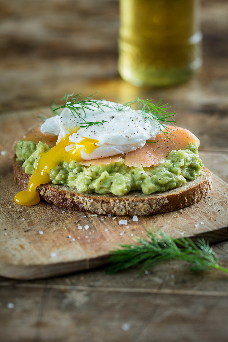 Bread topped with avocado cream, salmon and a poached egg