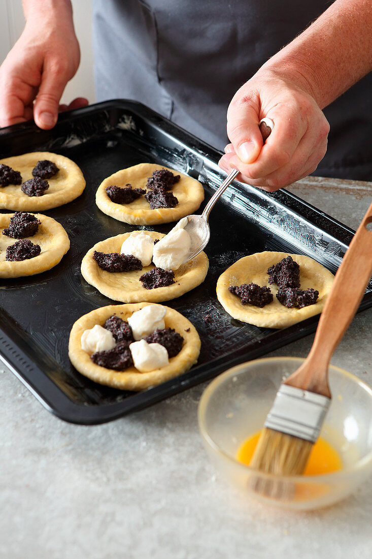 Kolach dough being topped with quark and poppyseeds