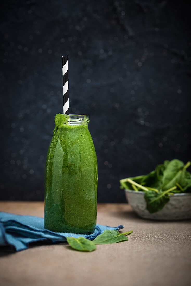 Vegan spinach smoothie in a glass bottle