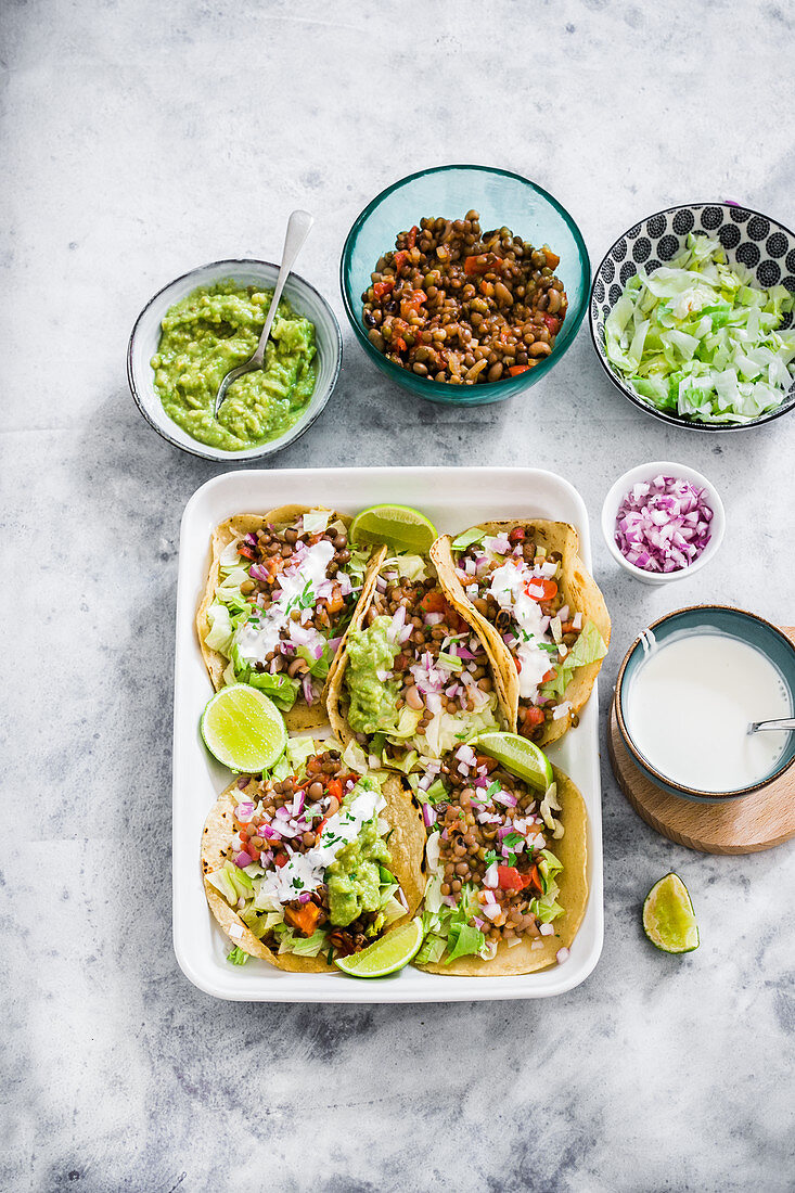 Lentils tacos with lattuce, onions, cream and guacamole sauce