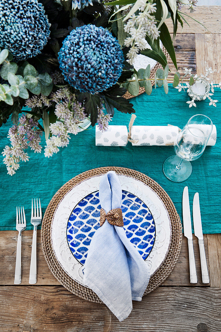 Laid table in aqua tones with floral decoration and table runner